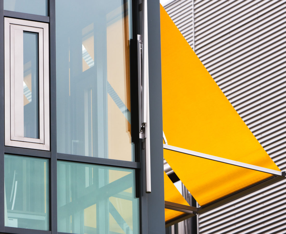 Closeup of a modern office building with yellow awnings